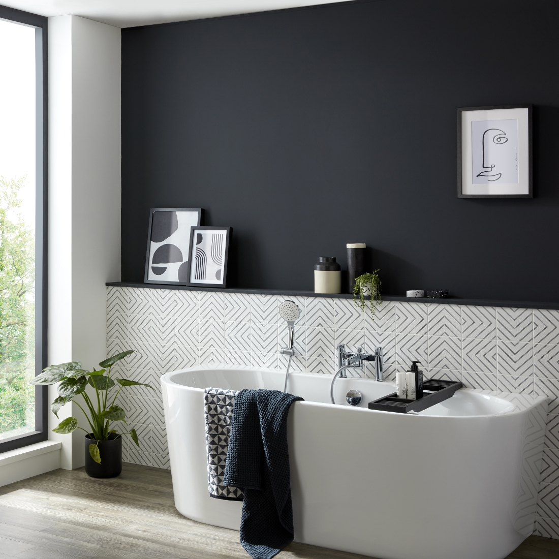 white bath tub with abstract tilling behind