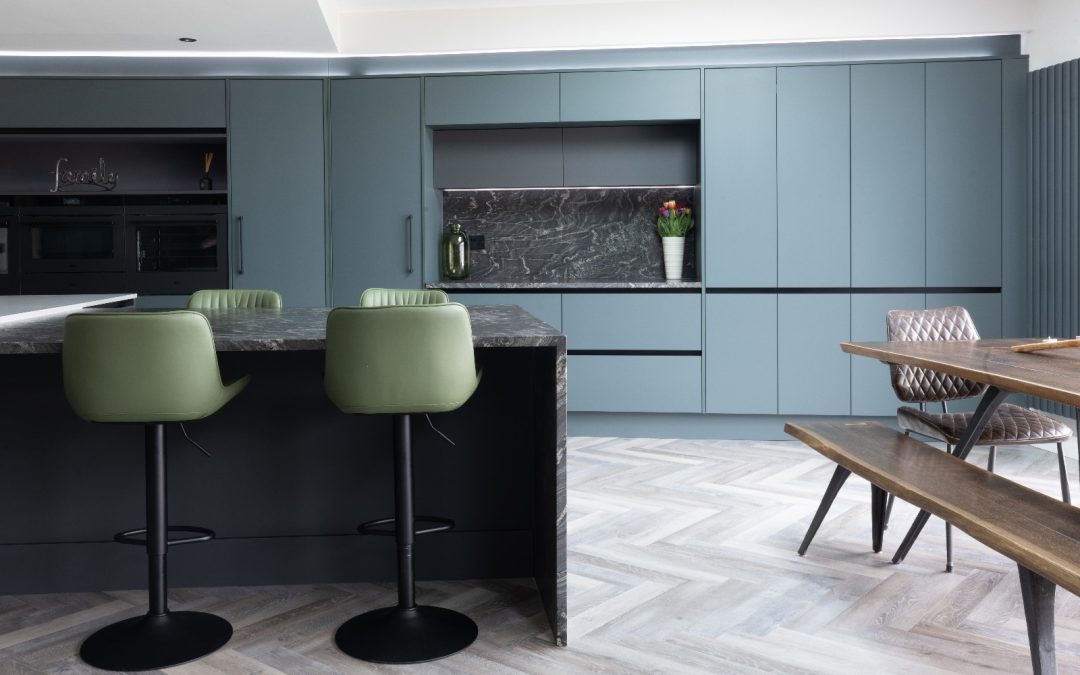 kitchen with blue units, a black granite island and dining table