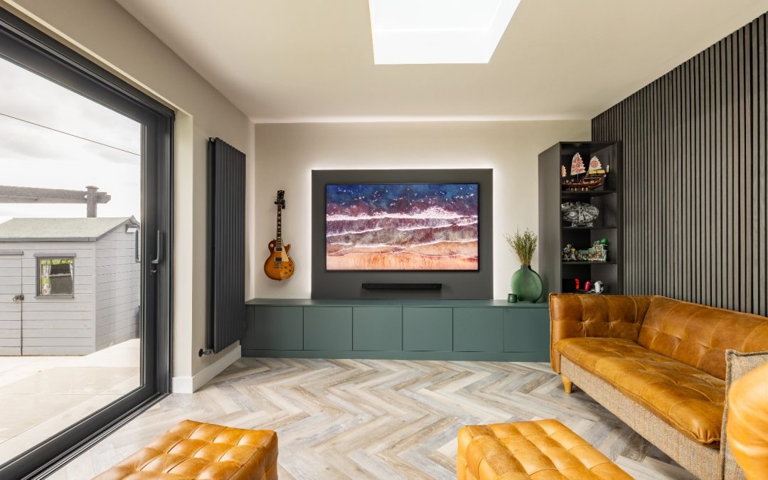 media wall with cupboards underneath and brown leather seating