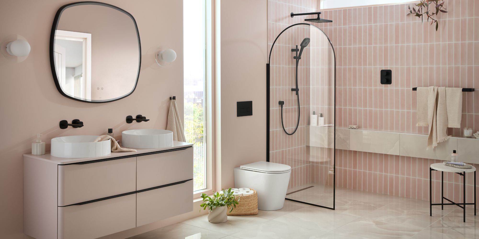 pink bathroom with walk in shower and double sinks